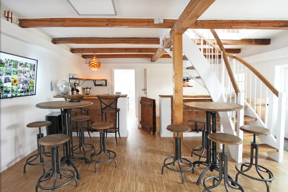 The lounge with high tables, seating, a coffee bar and stairs to the studio.