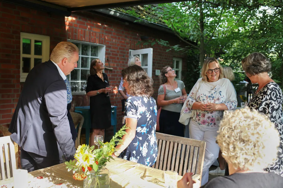 Event guests talking among seating areas on the terrace.