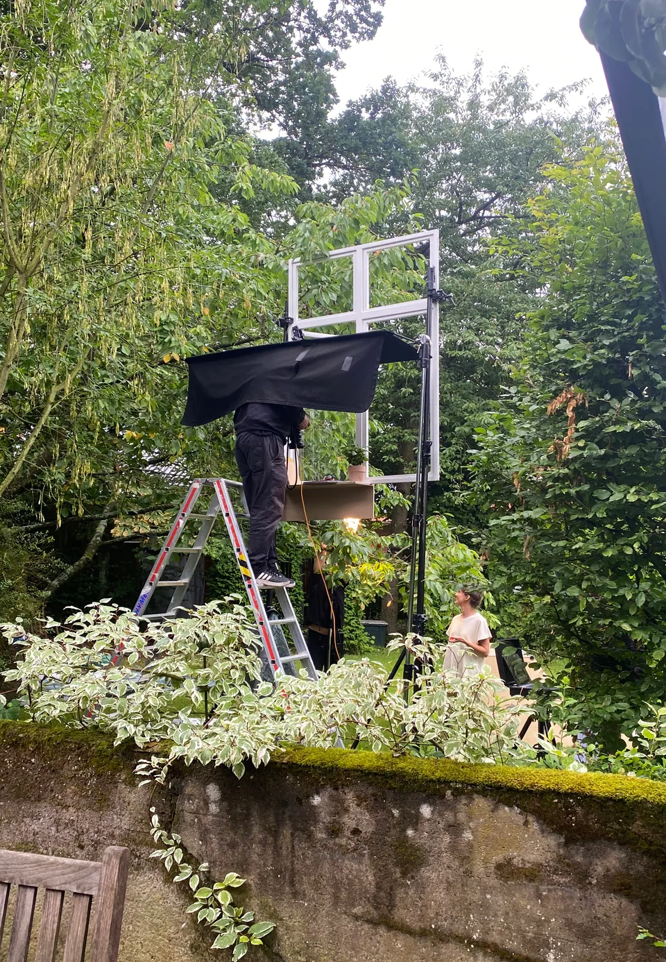 Aufbau mit Lichttechnik und einem Fensterrahmen für eine Produktion im Garten.